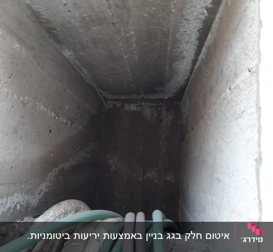 צינורות ירוקים ואפורים בתוך תעלת בטון